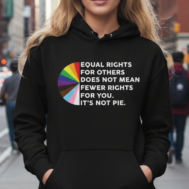 Woman wearing a black hoodie with a colorful equality message on a city street.