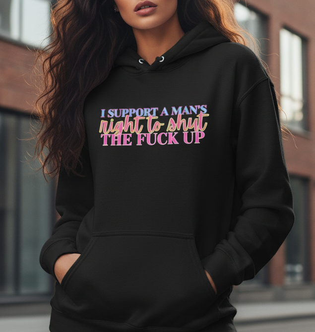 Person wearing a black hoodie with colorful text in an urban setting colorful quote "I support a man's right to shut the fuck up"