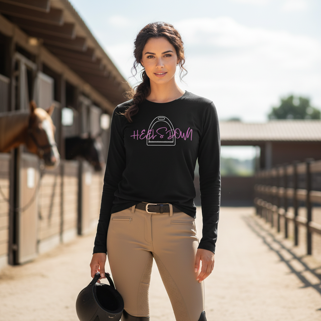 Woman in equestrian attire standing in a stable "Heels Down" 